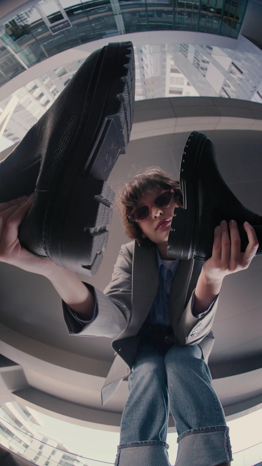A Man Sitting On Top Of A Pair Of Shoes In Front Of A Creative Design Generator Genflow テンプレートプレビュー