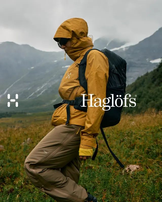 A Man In Yellow Jacket And Brown Pants Walking On Grass With Mountains In The Background Creative Design Generator Genflow template preview